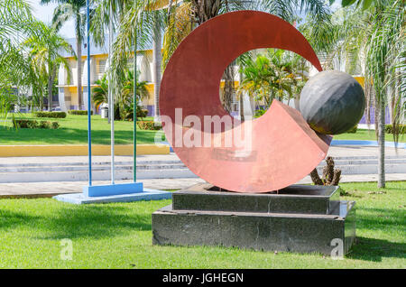 PORTO VELHO, BRAZIL - JUNE 15, 2017: Sculpture in front of the city hall of Porto Velho, surrounded by grass and trees. Red sculpture made of metal, r Stock Photo