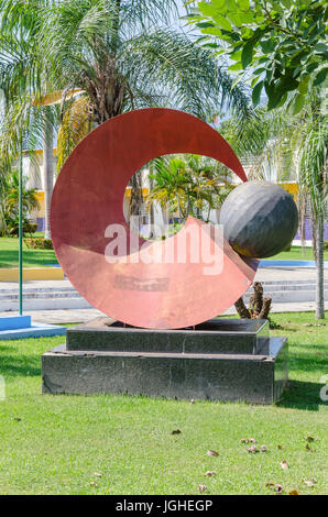 PORTO VELHO, BRAZIL - JUNE 15, 2017: Sculpture in front of the city hall of Porto Velho, surrounded by grass and trees. Red sculpture made of metal, r Stock Photo