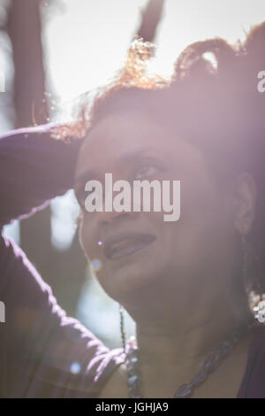 Middle aged woman with smile shot from below with severe lens flare and soft focus Stock Photo