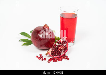 Fresh Pomegranate sliced with seeds and glass of juice on isolated white background Stock Photo