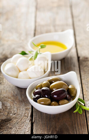 Olive oil, olives and mozzarella in bowls Stock Photo