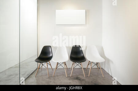 Empty office room, Glass window to the left .Loft interior style , white canvas print on the center white wall. Four black and white chairs at the con Stock Photo