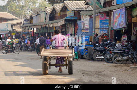 Bagan, Myanmar - Feb 20, 2016. A man pulling a wooden cart on street in Bagan, Myanmar. Bagan is one of the world greatest archeological sites, a sigh Stock Photo