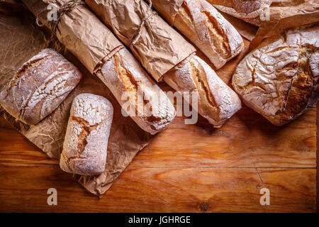 Different fresh breads on wooden table background Stock Photo
