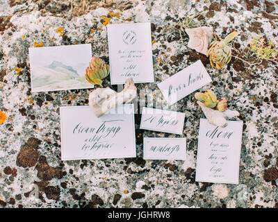 The close-up photo of the different postcards placed on the stone and decorated with different herbs. Stock Photo