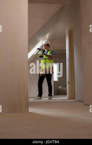 Construction Worker Using Drill To Install Replacement Window Stock Photo