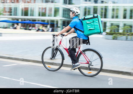 Courier On Bicycle Delivering Food In City Stock Photo