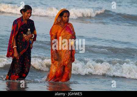 Women from the Hindu community bathe at the Bay of Bengal during the Rash Mela at Dublarchar in the Eastern Division of Sundarbans forest. Thousands o Stock Photo