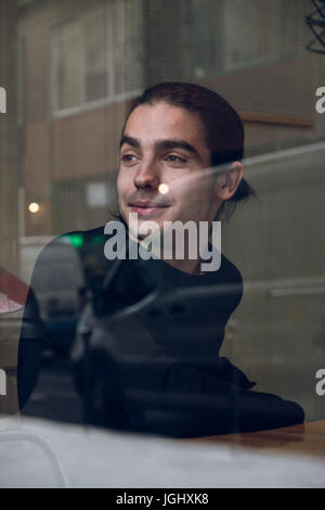 Portrait of a man looking out in a cafe window. Stock Photo