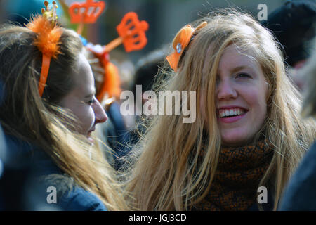 A blonde girl having fun and drinking on Kingsdad or the King's Day in Groningen, Netherlands. Stock Photo
