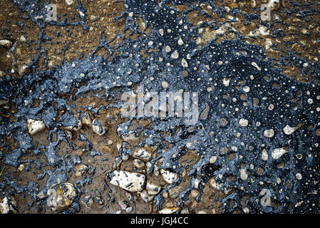 Black poured tar marks the pothole areas of a road so the holes in the old street can be repaired Stock Photo