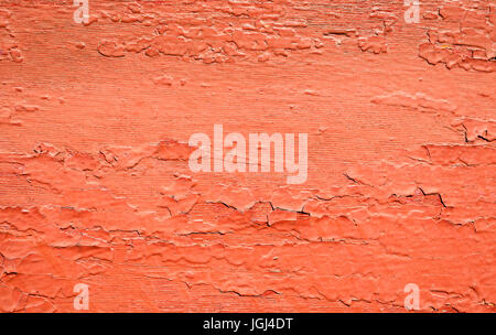 worn and flaking wood painted with a dark red bright prange paint Stock Photo