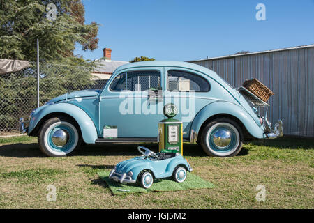 A Restored 1961 Volkswagen Beetle on display with a childs toy model VW and a small replica petrol bowser at Barraba Australia. Stock Photo