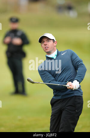 A policeman watches Northern Ireland's Rory McIlroy on the 10th fairway during day two of the Dubai Duty Free Irish Open at Portstewart Golf Club. Stock Photo