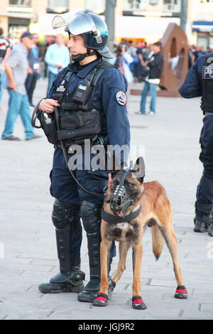MARSEILLE, FRANCE - JUNE 21, 2016: French policeman with the german shepherd dog patrolling the street in Marseille Stock Photo