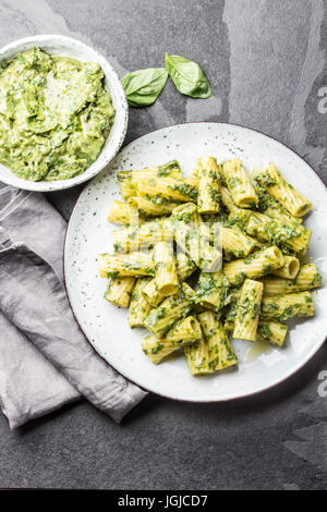 Pasta with green avocado herbs sauce. Top view, slate background Stock Photo