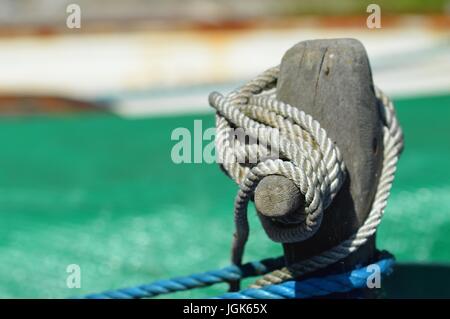 thick weathered orange rope coiled and tied to mooring post on boat rail  securing ship Stock Photo - Alamy