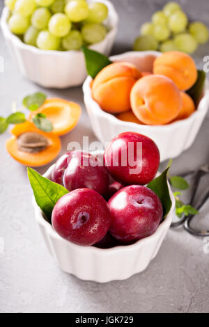 Various fruits in white bowls Stock Photo