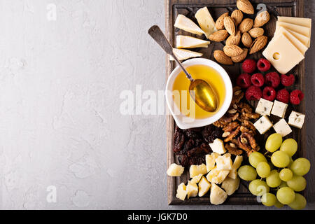 Cheese plate with nuts, honey and grapes Stock Photo