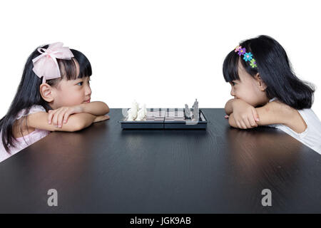 Asian Chinese little sisters playing chess together at home. Stock Photo