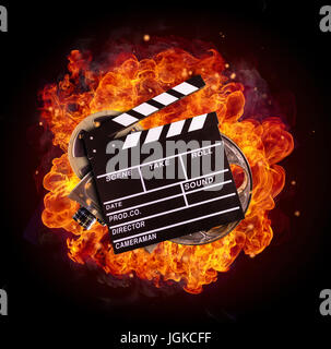 Film clapper, reel and camera in fire, isolated on black background. Concept of filmmaking. Stock Photo