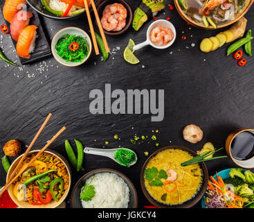 Asian food served on black stone, top view, space for text. Chinese and vietnamese cuisine set. Stock Photo