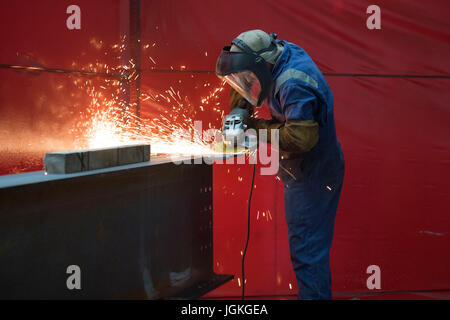 Workers at a steel fabrication facility welding and grinding steel in Caldicot, Wales, UK. Stock Photo