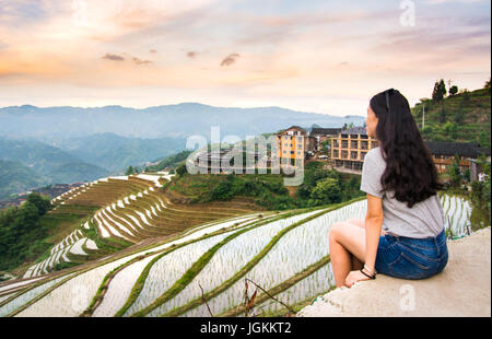 Girl enjoying sunset at terraced rice field in Longji, Guilin area, China Stock Photo