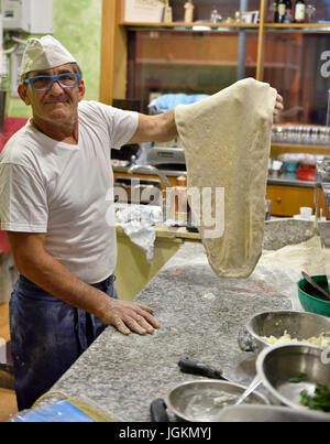 Italian pizza chef showing his hand crafted pizza base, Ristorante Pizzeria Trinchetto, Mondragone, Italy Stock Photo