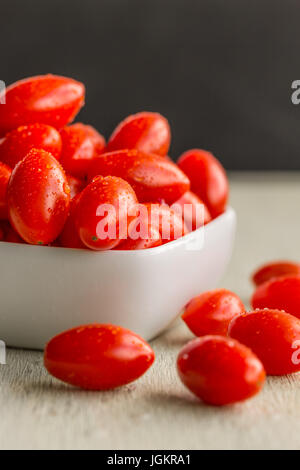 A group of cherry tomatoes in a white bowl Stock Photo