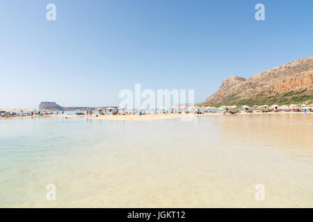 Sunbathers on a strip of sandy beach between sea and lagoon, Balos, north-west Crete, Greece, on the western side of the Gramvoussa peninsula. Stock Photo