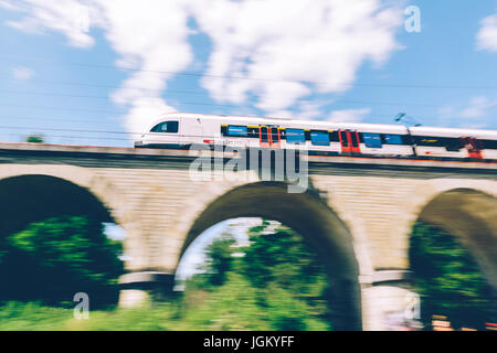 Geneva, Switzerland - June 25, 2017: Swiss regional train passing over a bridge in the Geneva Canton region, with motion blur.
