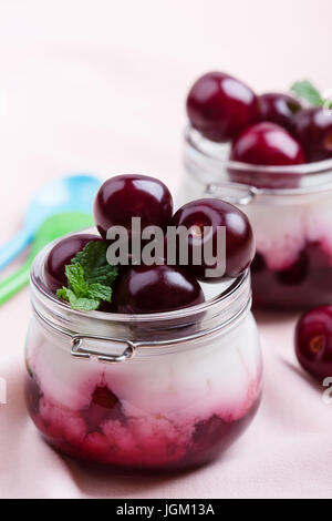 Traditional  Italian dessert panna cotta with fresh sweet cherry fruit  in glass jars Stock Photo