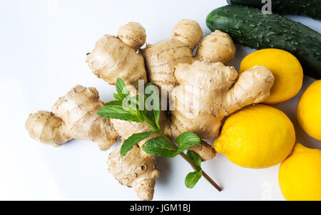 Ginger root with lemons and cucumbers on white Stock Photo