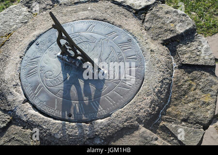 A brass sundial mounted on a stone plinth Stock Photo