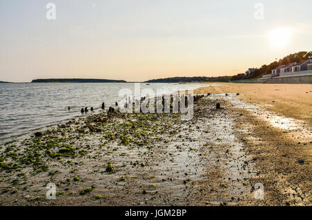 Wellfleet beach during sunset with old pier and ocean in Cape Cod Stock Photo