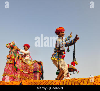 PUSHKAR, INDIA - MAR 7, 2012. Rajasthani folk dancers in colorful ethnic attire perform in Pushkar, India. Pushkar is known around the world for its P Stock Photo