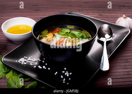 Tuscan vegetable soup with basil pesto in black plate Stock Photo
