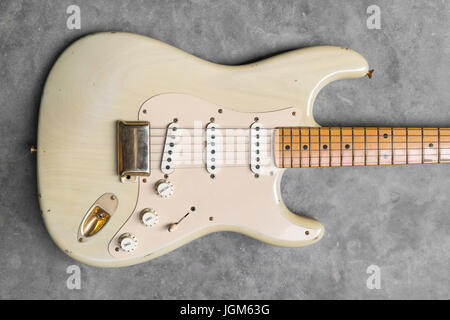 detail of vintage electric guitar body on the concrete background. Stock Photo