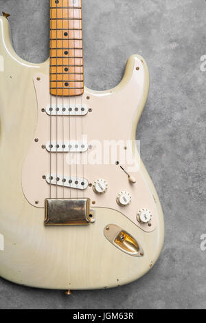 detail of vintage electric guitar body on the concrete background. Stock Photo