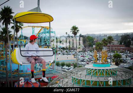 Boy sitting in a cart on the Santa Cruz Beach Boardwalk Skyglider Stock Photo