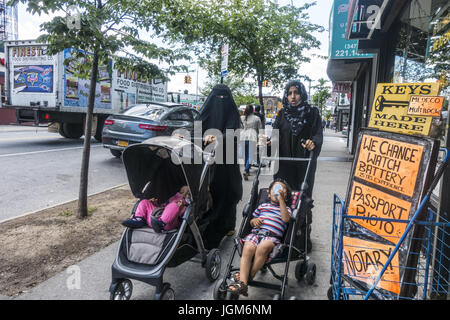 Two Muslim mothers pushing their children up Church Avenue in the highly multi-cultural Kensington neioghborhood of Brooklyn, NY. Stock Photo