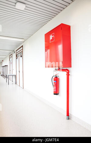 an fire hose hanging on the wall in an staircase Stock Photo