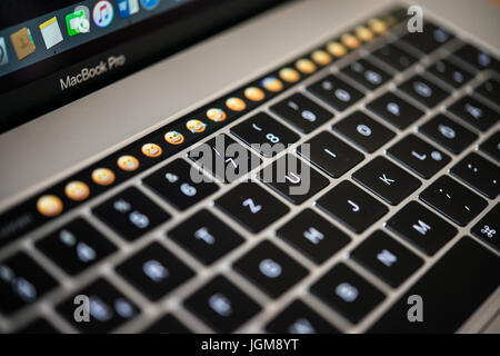 Backlit keyboard and Touch Bar showing emoticons, laptop, Apple MacBook Pro, close-up Stock Photo