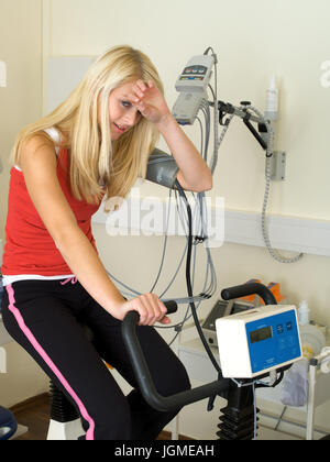Young woman carries out an ergometer test in the medical practise - Young woman on an ergometer in the surgery, Junge Frau führt einen Ergometer-Test Stock Photo