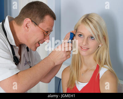 Doctor examines a young woman in the ear - Young woman, doctor, ear ex-Yank's nation, Arzt untersucht eine junge Frau im Ohr - Young woman, ear examin Stock Photo