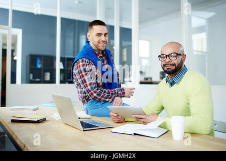 Happy young co-workers having coffee break in office Stock Photo