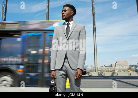 Young trader standing by highway in modern city Stock Photo