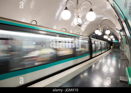PARIS - JUN 19, 2015: Metro train leaving a Paris Metro station. Paris Metro is the 2nd largest underground system worldwide by number of stations (30 Stock Photo