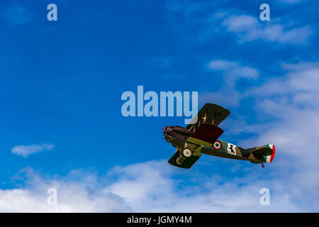 Flying biplane Spad S XIII replica from first world war between the clouds. Stock Photo